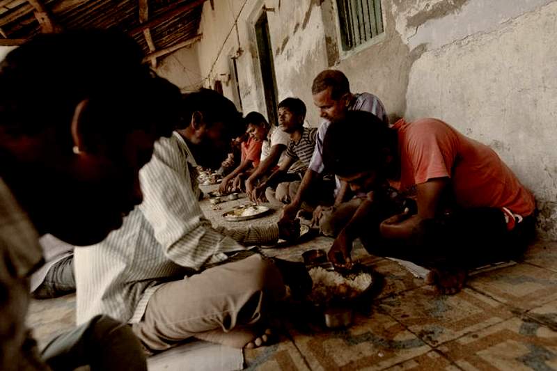People sitting and having food in village
