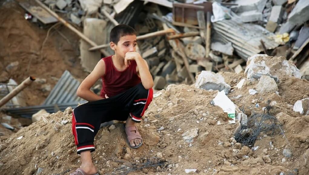 Child sitting on debris, War